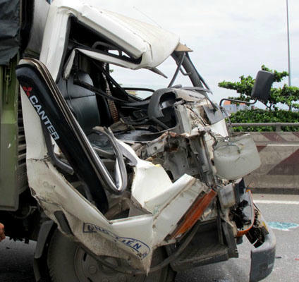 Xe tải bẹp dúm phần đầu, người dân phải phá cửa giải cứu phụ xe đưa đi cấp cứu