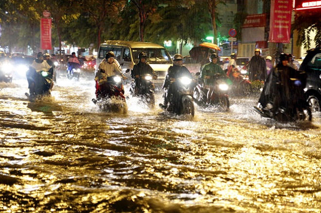 Người dân TP.HCM “vượt lụt” về nhà