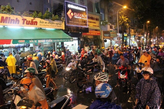 Người dân TP.HCM “vượt lụt” về nhà