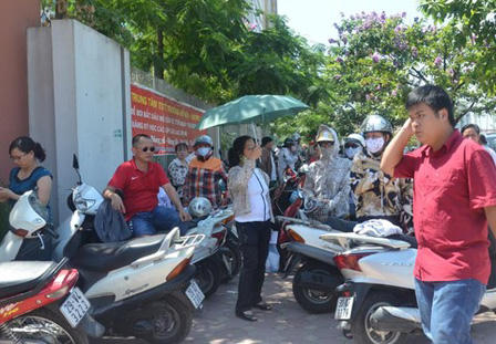 Phụ huynh vật lộn với nắng nóng đưa con đi thi tốt nghiệp