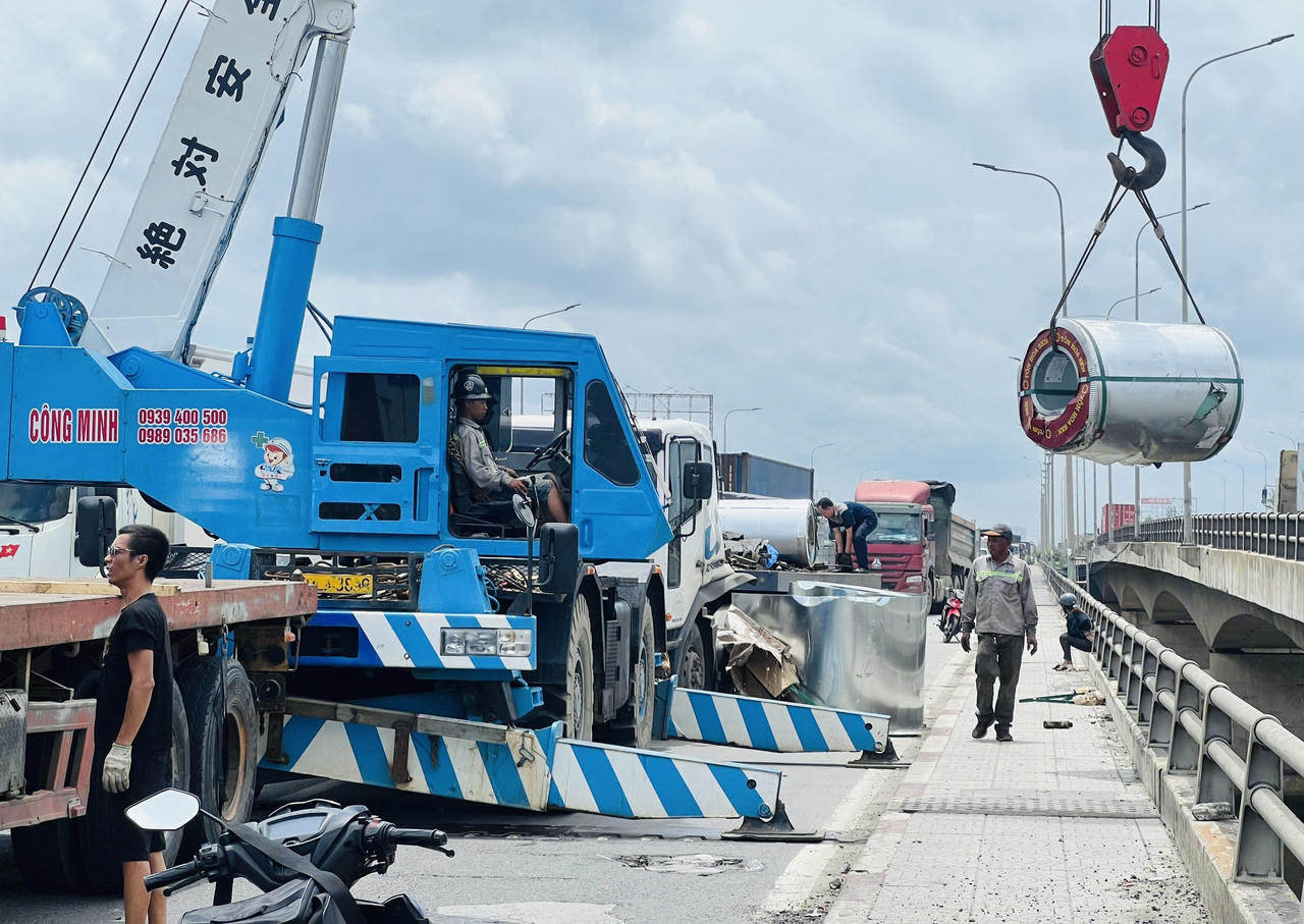 Xe đầu kéo phanh gấp, hàng chục tấn tôn cuộn rơi xuống quốc lộ 1