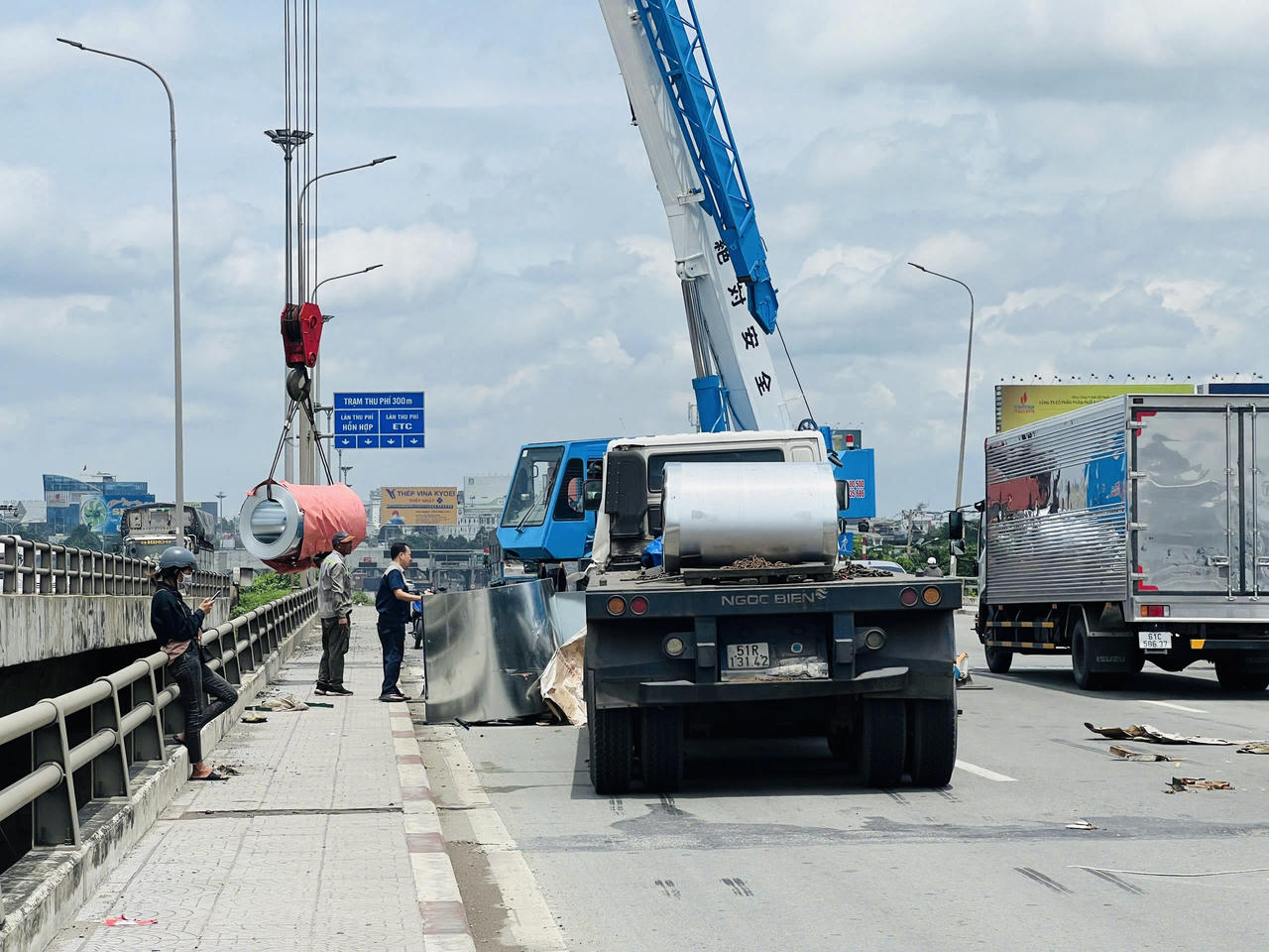 Xe đầu kéo phanh gấp, hàng chục tấn tôn cuộn rơi xuống quốc lộ 1