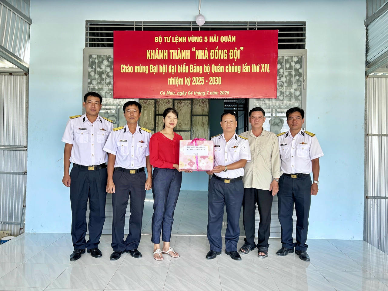 Thượng tá Phạm Khắc Đông - Chính ủy Trung tâm Bảo đảm Kỹ thuật – Hậu cần tặng quà gia đình quân nhân trong dịp khánh thành nhà mới