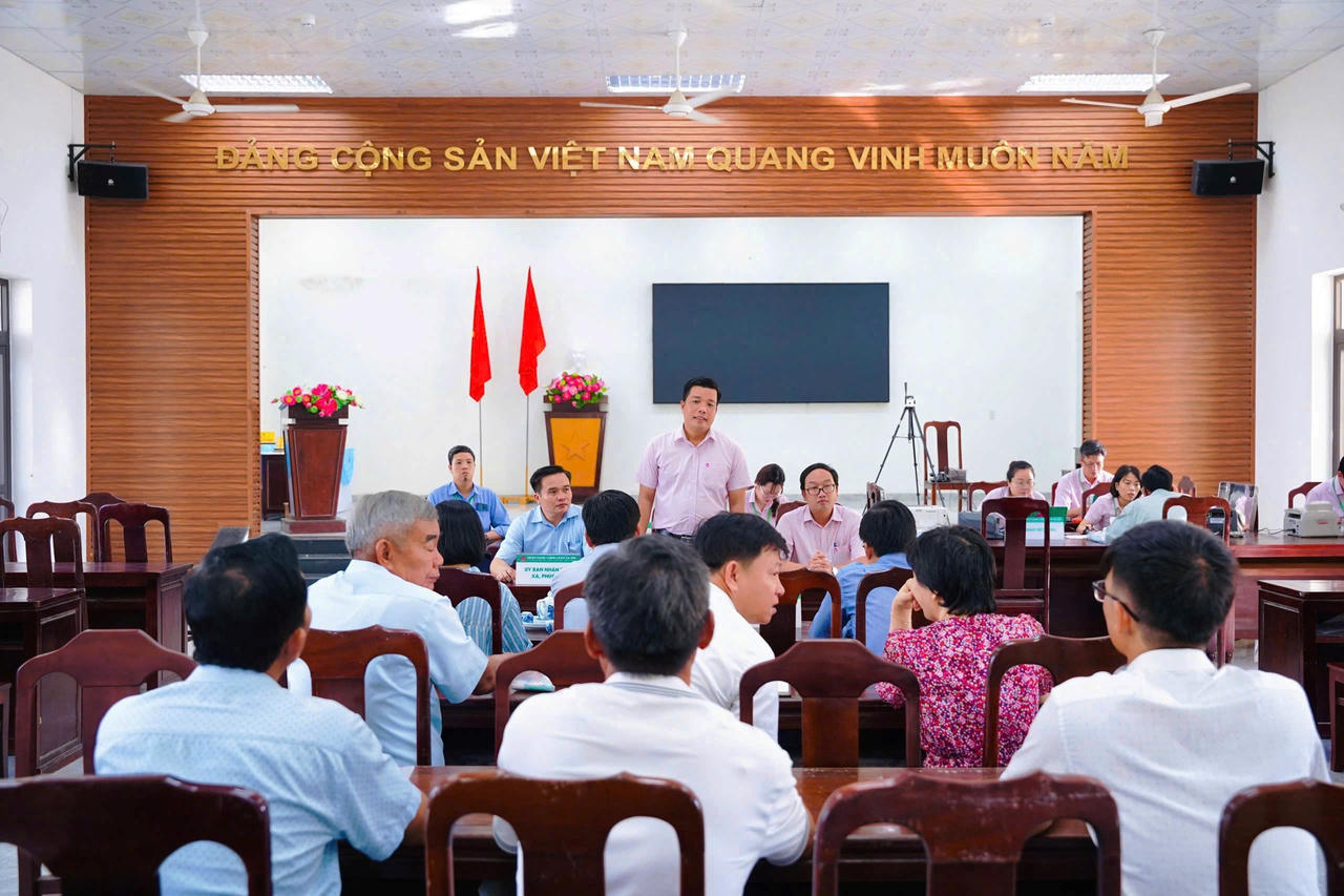 Ông Đào Bá Thuận, Phó Giám đốc Chi nhánh NHCSXH TP Huế trao đổi với người dân tại phiên giao dịch. 