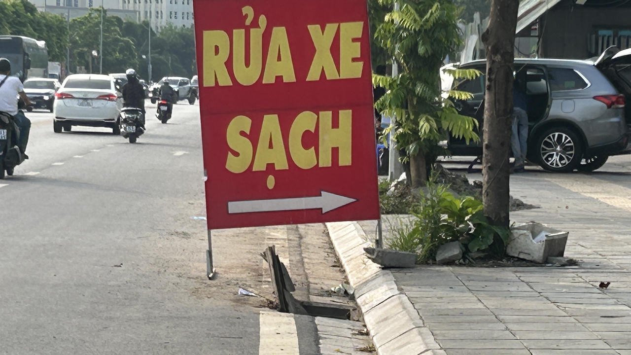 Một biển quảng cáo của tiệm rửa xe ven đường được tận dụng để làm cảnh báo cho người và phương tiện khi di chuyển qua đây.