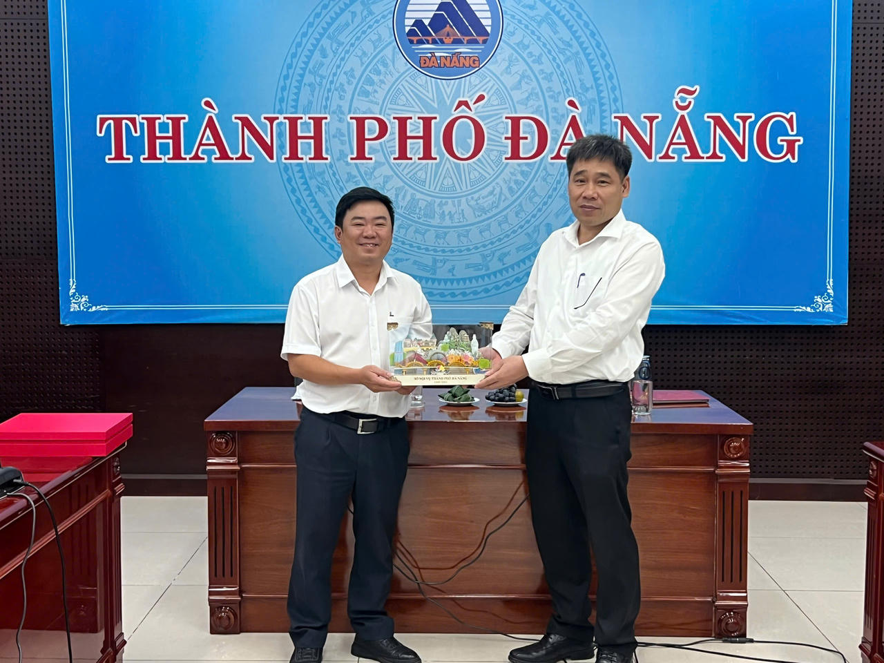  TS. Đậu Tuấn Nam - đại diện Học viện Chính trị quốc gia Hồ Chính Minh nhận quà lưu niệm do ông Trần Trung Sơn - đại diện lãnh đạo Thành phố Đà Nẵng trao tặng.