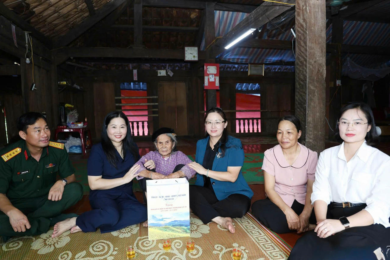Tặng quà bà Hoàng Thị Hiên, mẹ liệt sĩ. (Ảnh: Báo Lào Cai)