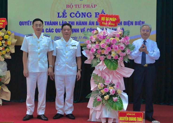 Phó Bí thư chuyên trách Đảng ủy Bộ Tư pháp Nguyễn Quang Thái tặng hoa chúc mừng.