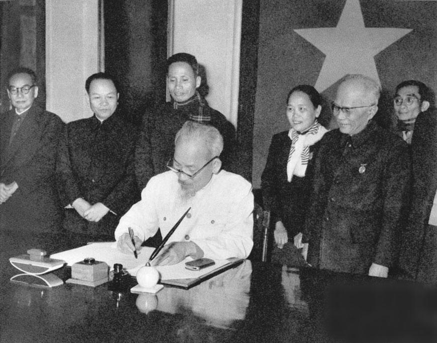 Chủ tịch Hồ Chí Minh ký sắc lệnh công bố Hiến pháp năm 1959. Bộ trưởng Bộ Tư pháp Vũ Đình Hòe đứng ngoài cùng, bên trái. Ảnh tư liệu 