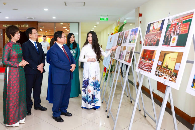 Thủ tướng Phạm Minh Chính và Phó Thủ tướng Mai Văn Chính tham quan trưng bày ảnh của TTXVN - Ảnh: VGP/Nhật Bắc