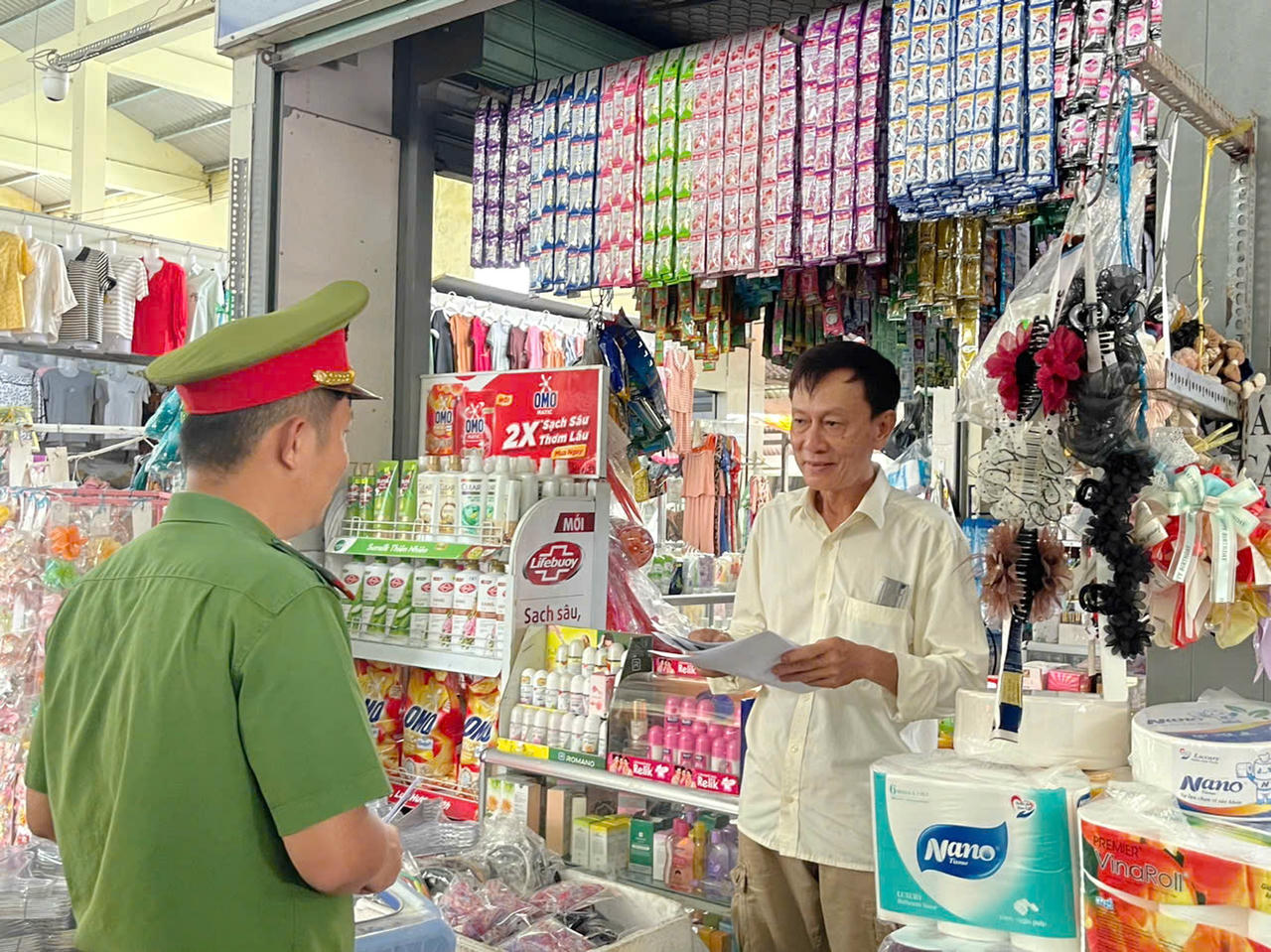 Cán bộ Công an phường Bạc Liêu phát tờ rơi tuyên truyền về Luật PCCC và CNCH cho hộ kinh doanh trên địa bàn phường.