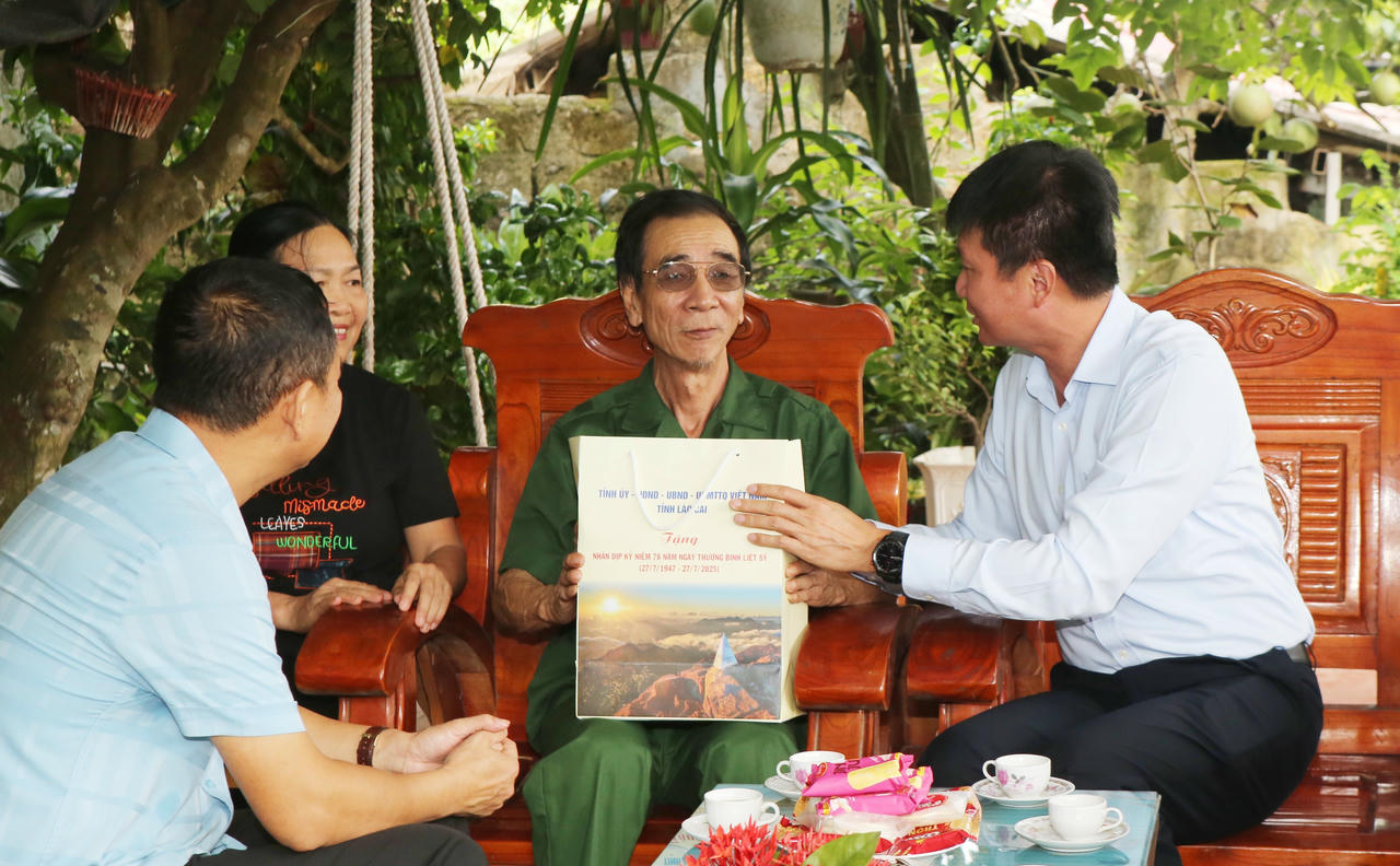 Chủ tịch UBND tỉnh Lào Cai tặng quà, động viên cựu chiến binh Hoàng Văn Phiến. (Ảnh: Báo Lào Cai)