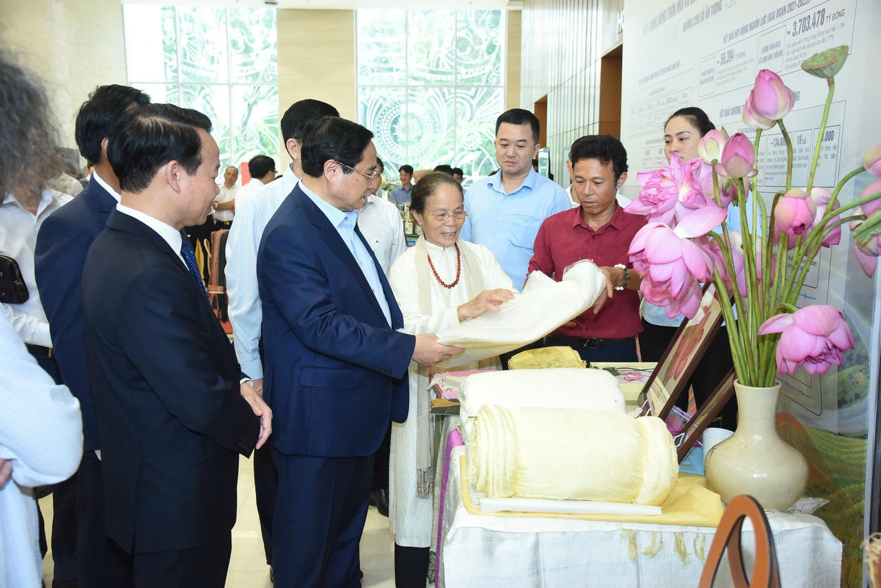 Nghệ nhân ưu tú Phan Thị Thuận và sản phẩm Tơ sen vinh dự được đón Thủ tướng Phạm Minh Chính cùng các đại biểu tham quan gian trưng bày.