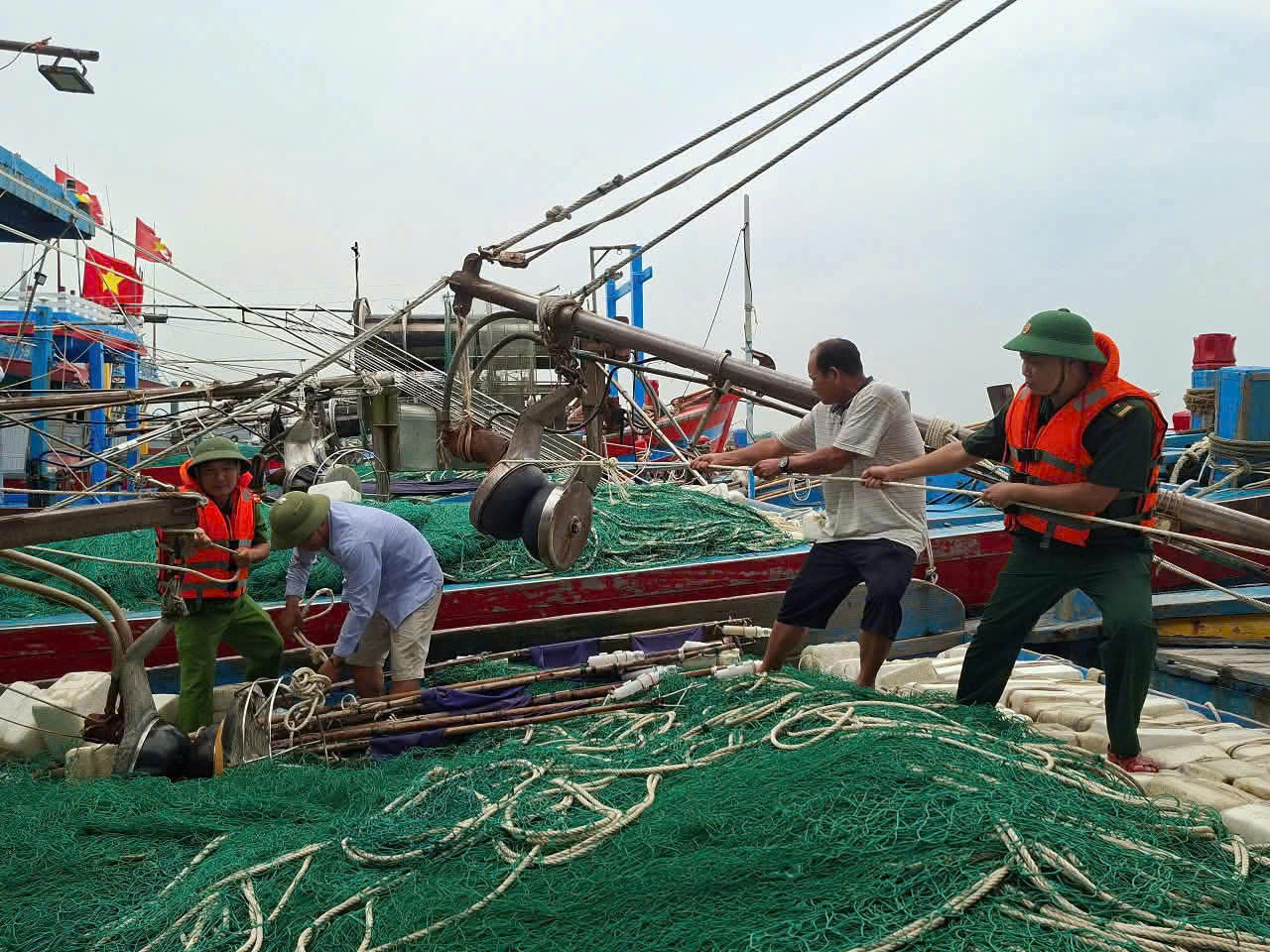 Cán bộ chiến sỹ đồn Biên phòng Cửa khẩu cảng Hải Thịnh giúp ngư dân neo đậu tàu thuyền và kêu gọi vào nơi tránh trú an toàn.