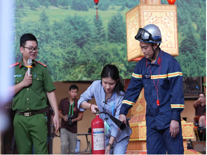 Học viên được hướng dẫn kỹ năng sử dụng bình chữa cháy xách tay để dập tắt đám cháy (Ảnh: Công an Hà Nội)