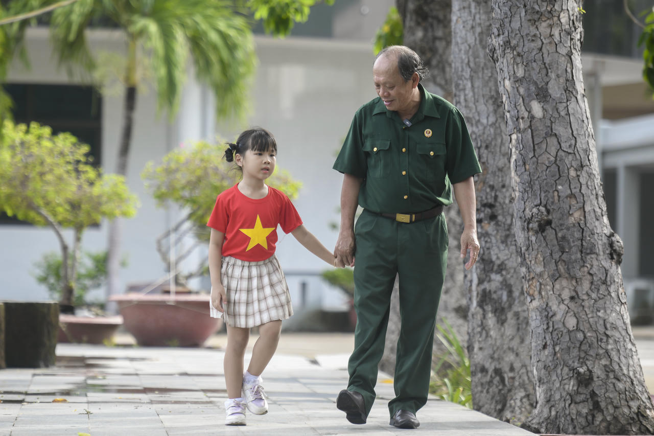 Thượng sĩ Nguyễn Chí Tường cùng con một nhân viên Vinamilk tại Trung tâm Điều dưỡng Thương binh và Người có công Long Đất. Ảnh: Thanh Bình.