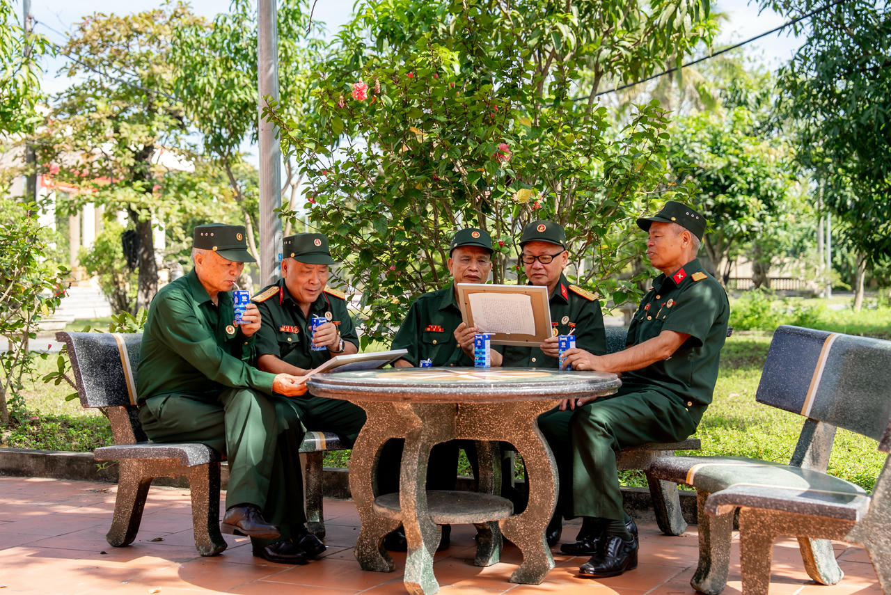 Các bác cựu chiến binh chăm chú đọc những dòng chữ nhỏ, được các em gửi kèm trong mỗi bức tranh. Ảnh: Duy Cường.