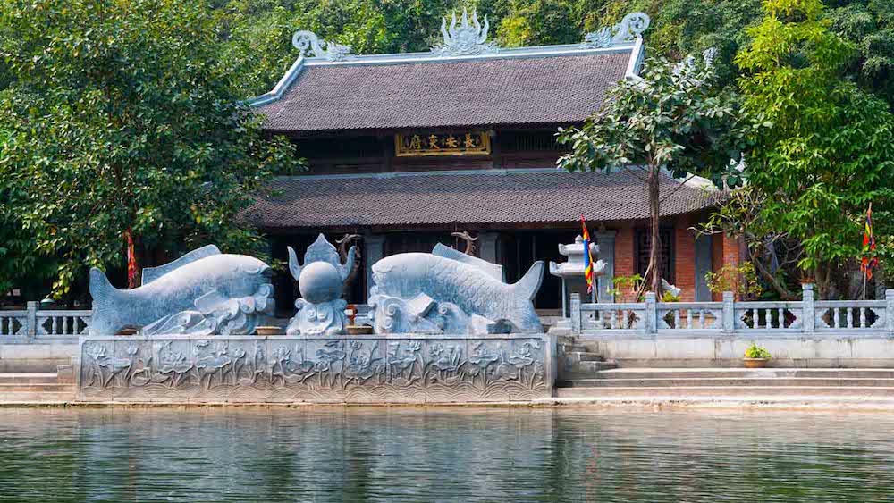 Đền Trình với lối kiến trúc cổ cùng với hai bức tượng hình cá chép lớn trước cổng đền