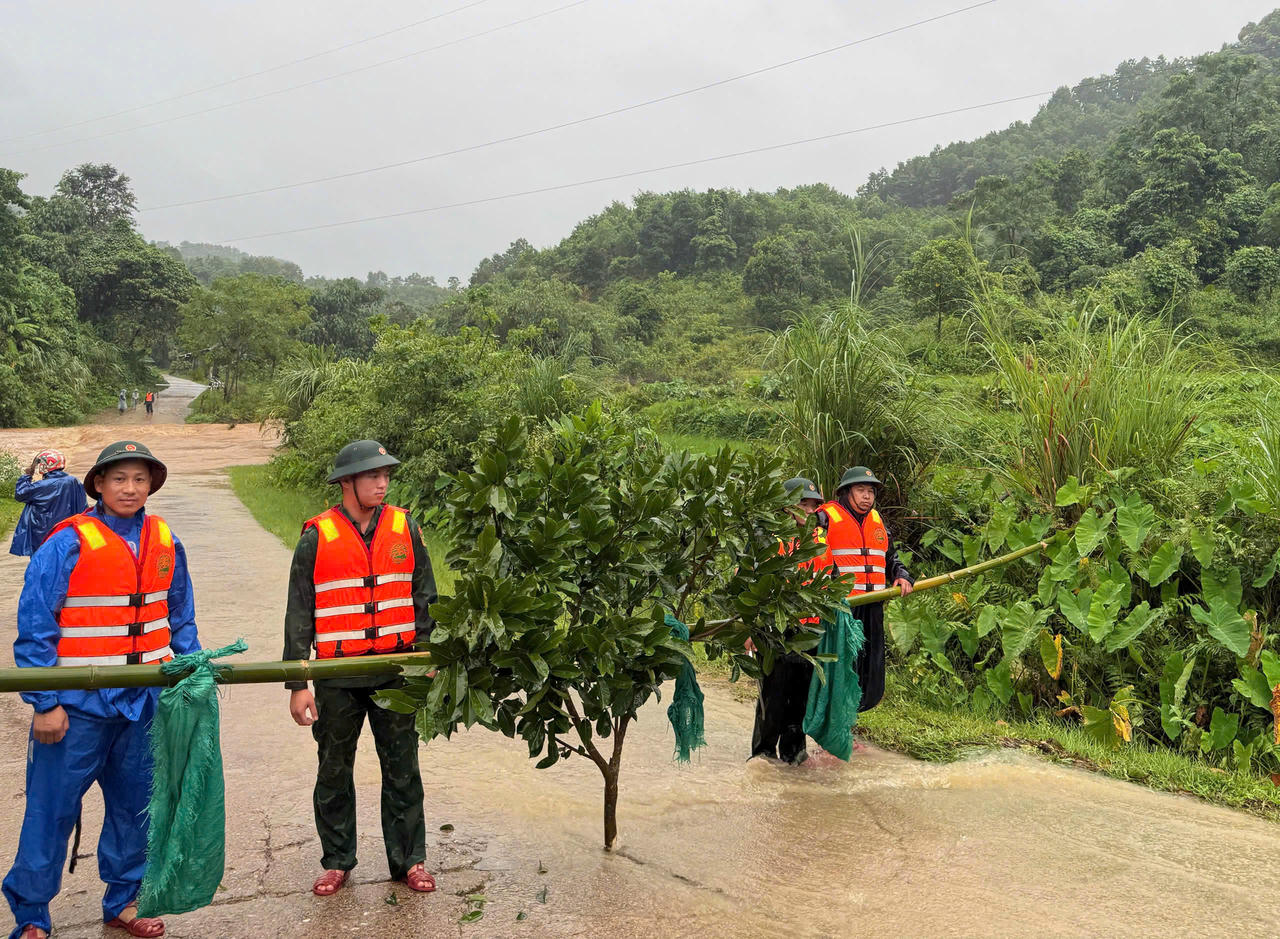 Cán bộ chiến sĩ chốt chặn, hướng dẫn người dân không di chuyển qua khu vực ngập lụt.