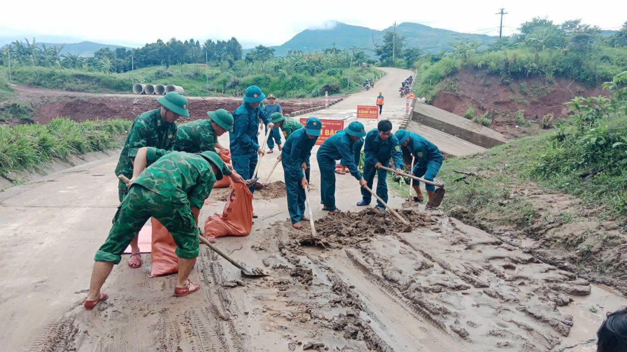 Cán bộ, chiến sĩ Đồn Biên phòng Thanh cùng với dân quân địa phương dọn dẹp bùn đất trên các tuyến đường liên thôn.