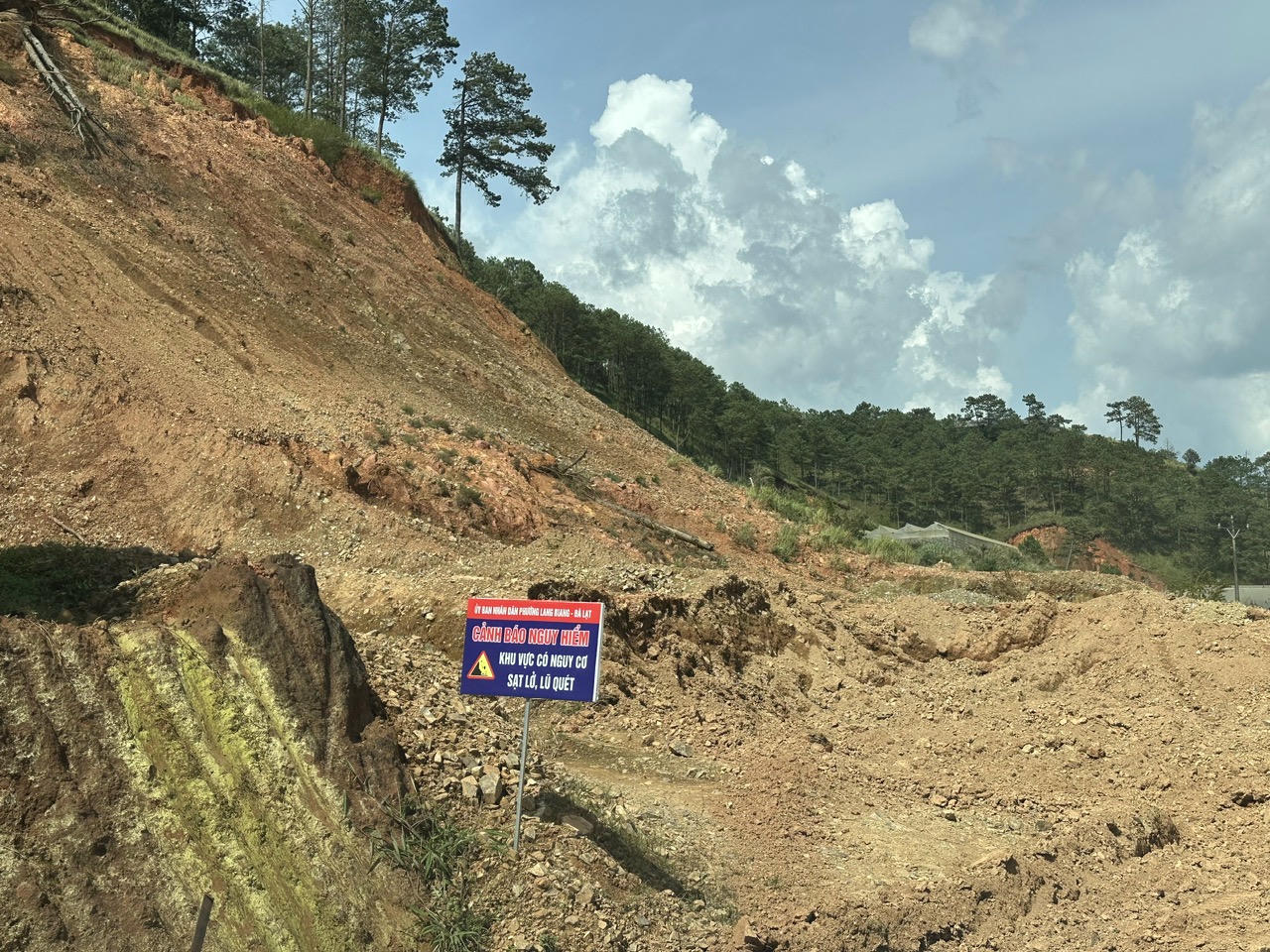 Một vị trí sạt trượt được nhà chức trách cắm biển cảnh báo. Trong khi Lâm Đồng hiện đang là mùa mưa nên nguy cơ sạt trượt đất rất cao.