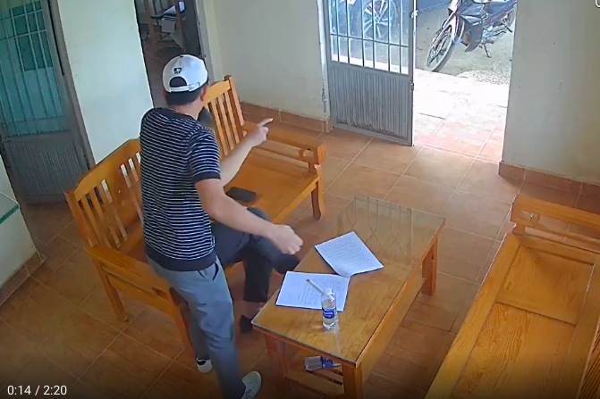 Người đàn ông dùng tay dúi đầu Trạm trưởng Trạm quản lý bảo vệ rừng Suối Cạn Phạm Công Nguyên.