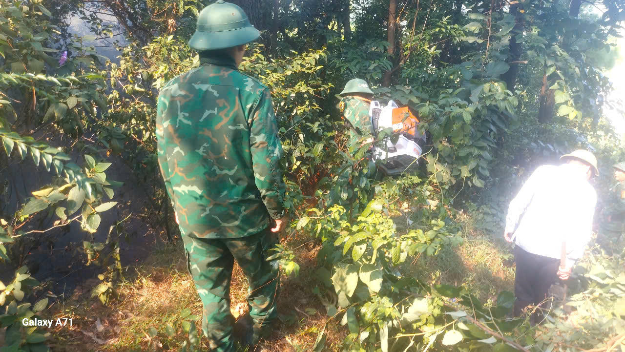 Cán bộ, chiến sĩ Đồn Biên phòng Roòn và người dân tạo đường băng cản lửa ngăn cháy lan.