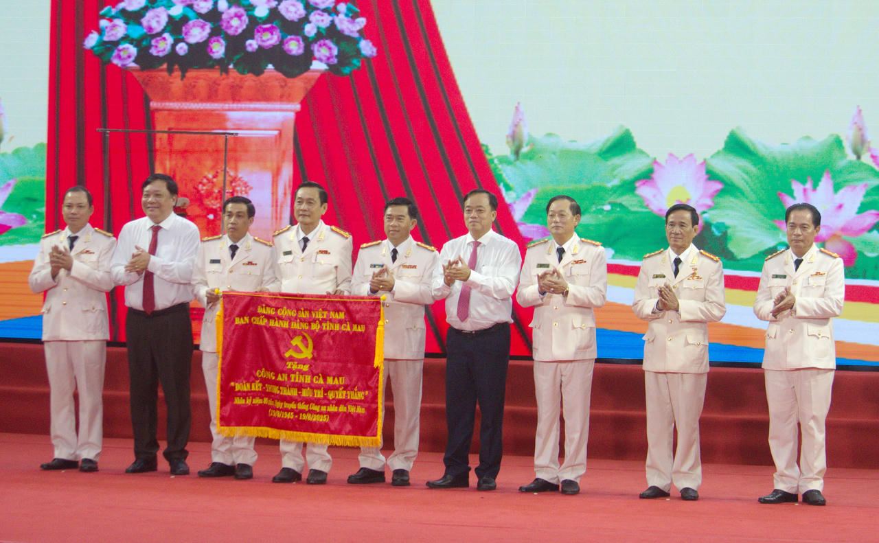 Ông Huỳnh Quốc Việt - Ủy viên dự khuyết BCH TW Đảng, Phó Bí thư Thường trực Tỉnh ủy (bên phải) và ông Phạm Thành Ngại - Phó Bí thư Tỉnh ủy, Chủ tịch UBND tỉnh trao tặng bức trướng của Tỉnh ủy Cà Mau cho Công an tỉnh.