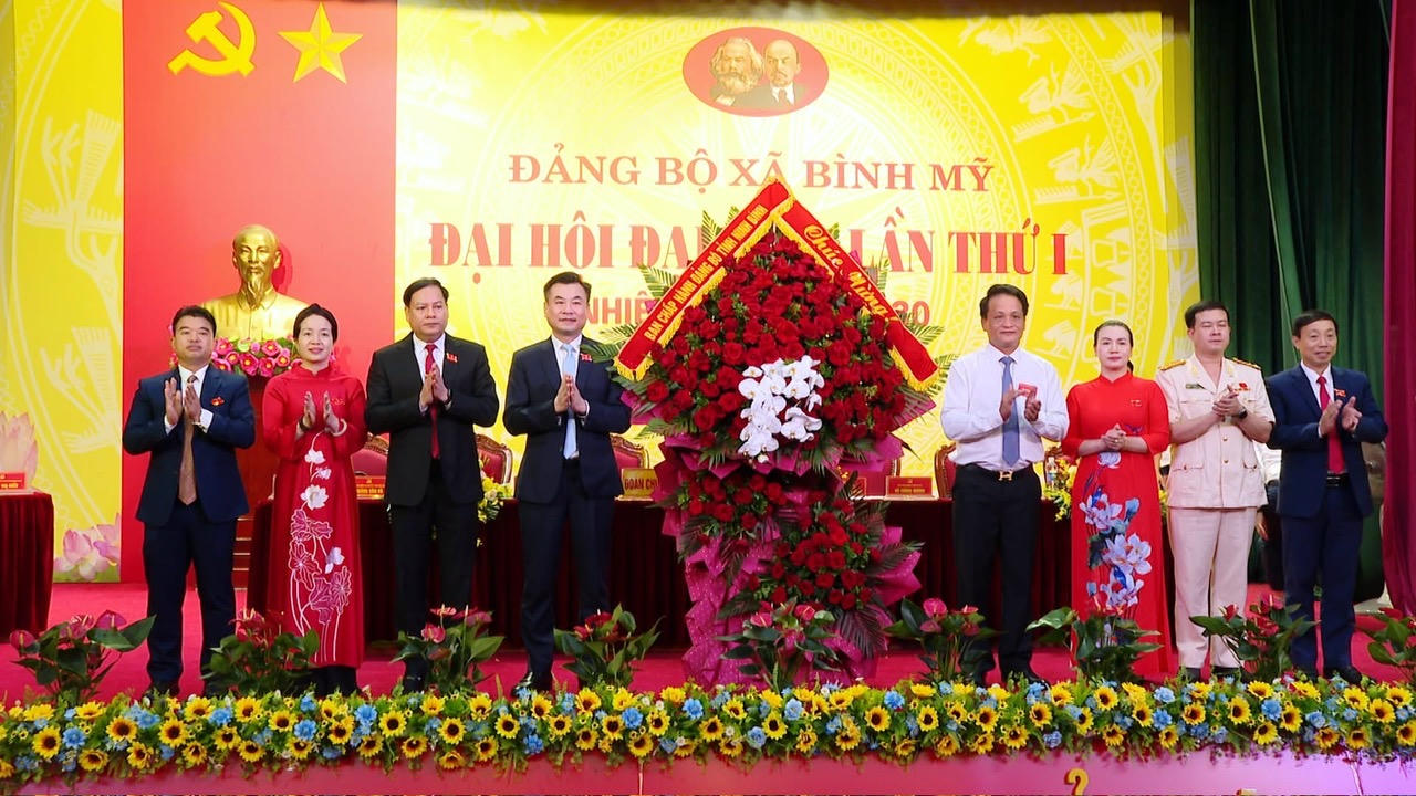 Ông Đào Đình Tùng - Ủy viên Ban Thường vụ Tỉnh ủy, Bí thư Đảng ủy, Chủ tịch HĐND phường Phủ Lý tặng hoa chúc mừng Đại hội Đảng bộ xã Bình Mỹ.