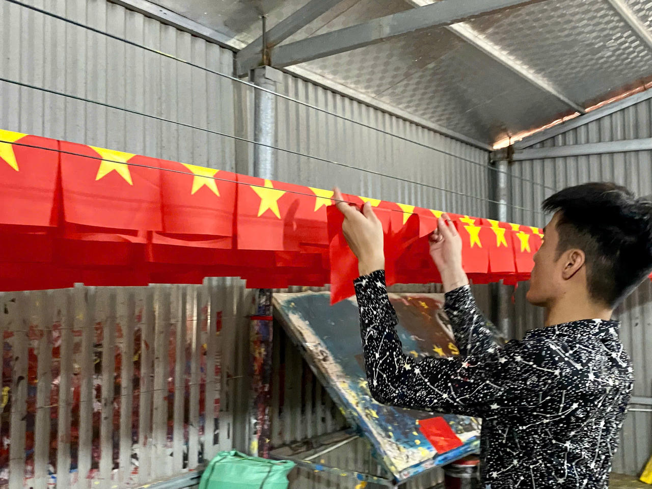 Những lá cờ Tổ quốc rực đỏ được phơi ngay ngắn, sẵn sàng gửi đi khắp mọi miền đất nước