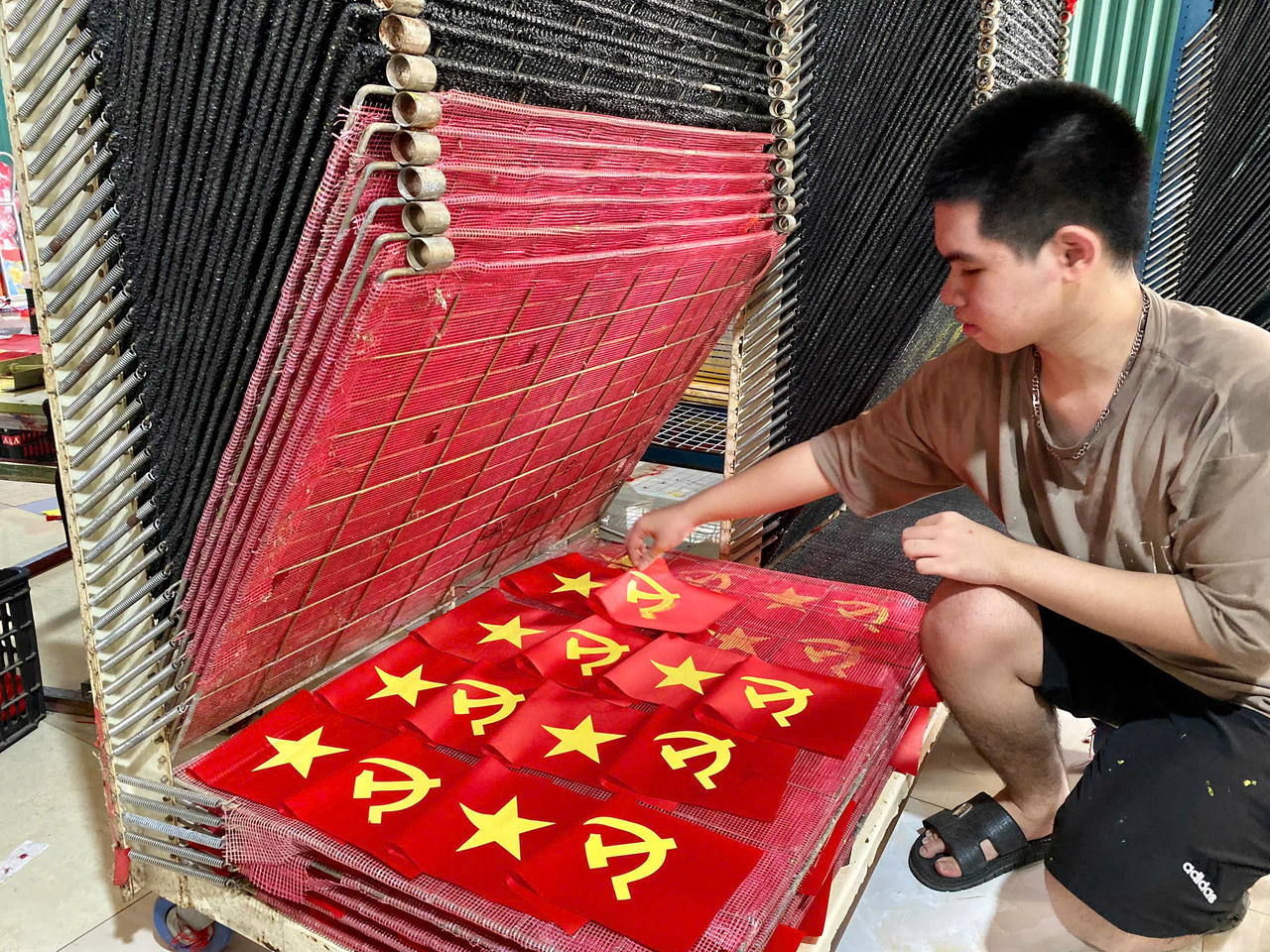 Công đoạn in lụa thủ công giúp tạo màu sắc sắc nét cho những lá cờ sắp xuất xưởng