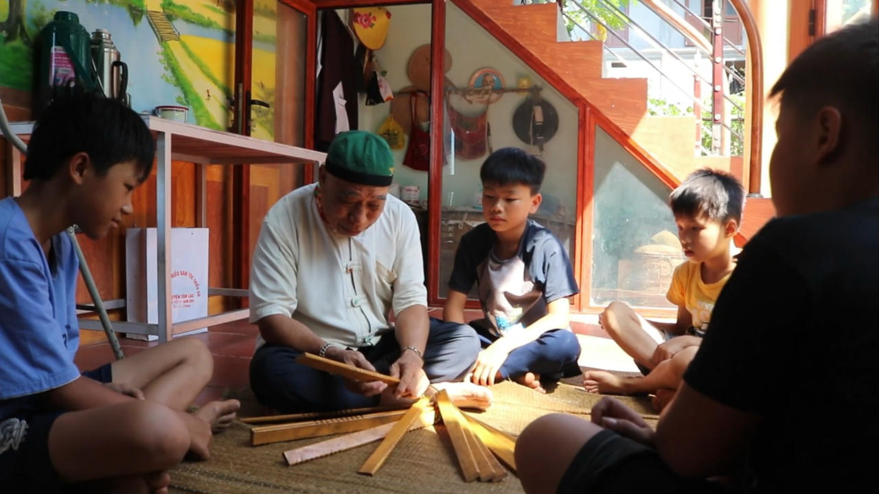 Ông Khẩn dạy các em dùng lịch Đoi. Ảnh: Hoàng Phương và cộng sự.