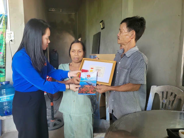 Đại diện gia đình nhận huy hiệu “Tuổi trẻ dũng cảm” do Trung ương Đoàn truy tặng anh Nguyễn Đầu.