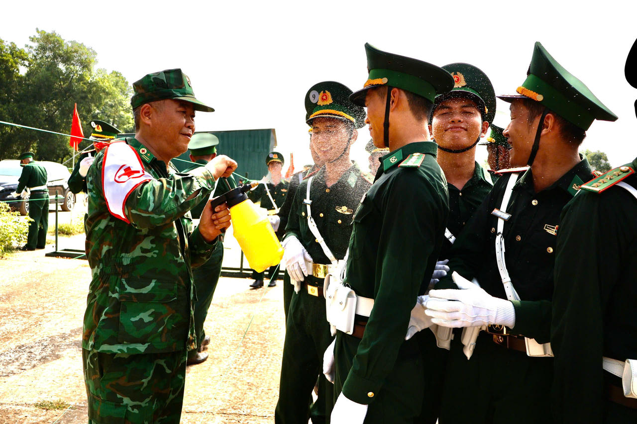 Cán bộ quân y phun sương làm mát, chăm sóc sức khoẻ cho các chiến sĩ trong đội hình diễu binh A80 sau giờ tập luyện ngoài thao trường. (Ảnh: PV).