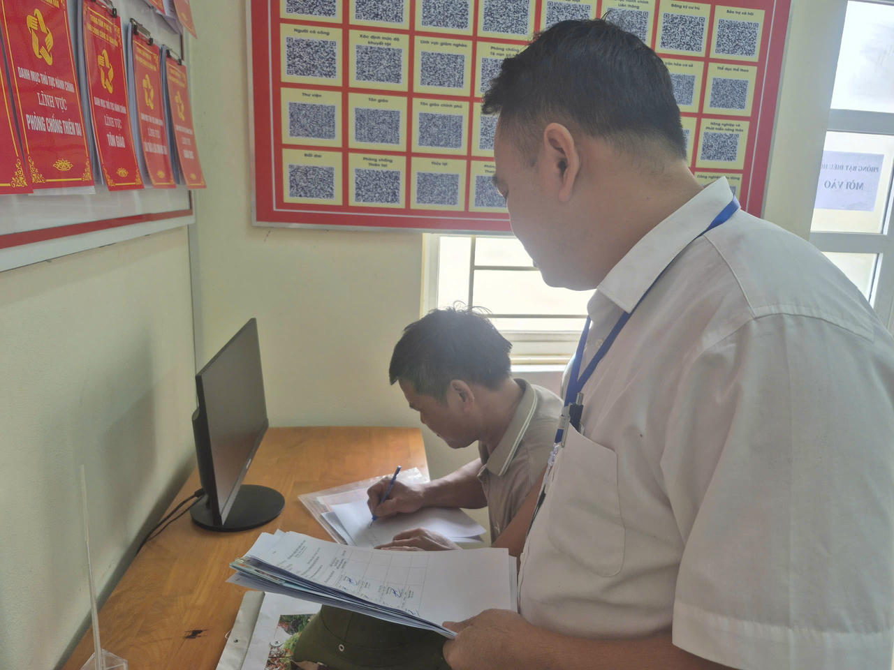 Cán bộ, công chức xã Xuân Vân – Tuyên Quang hướng dẫn người dân làm thủ tục hành chính. Ảnh: Nhật Nguyên.