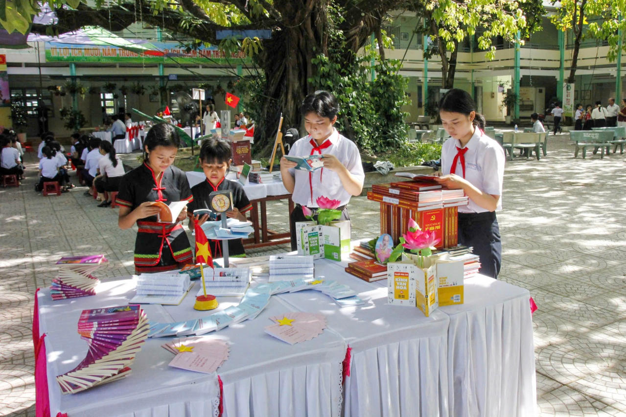 Các em học sinh thích thú với những quyển sách mới.