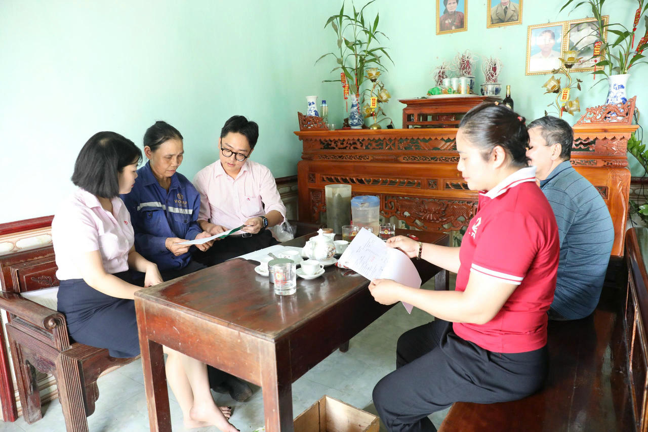 Cán bộ Ngân hàng chính sách xã hội kiểm tra sổ vay vốn của hộ bà Nguyễn Thị Tú (áo xanh) ở xã Tu Vũ. Ảnh: Xuân Hồng