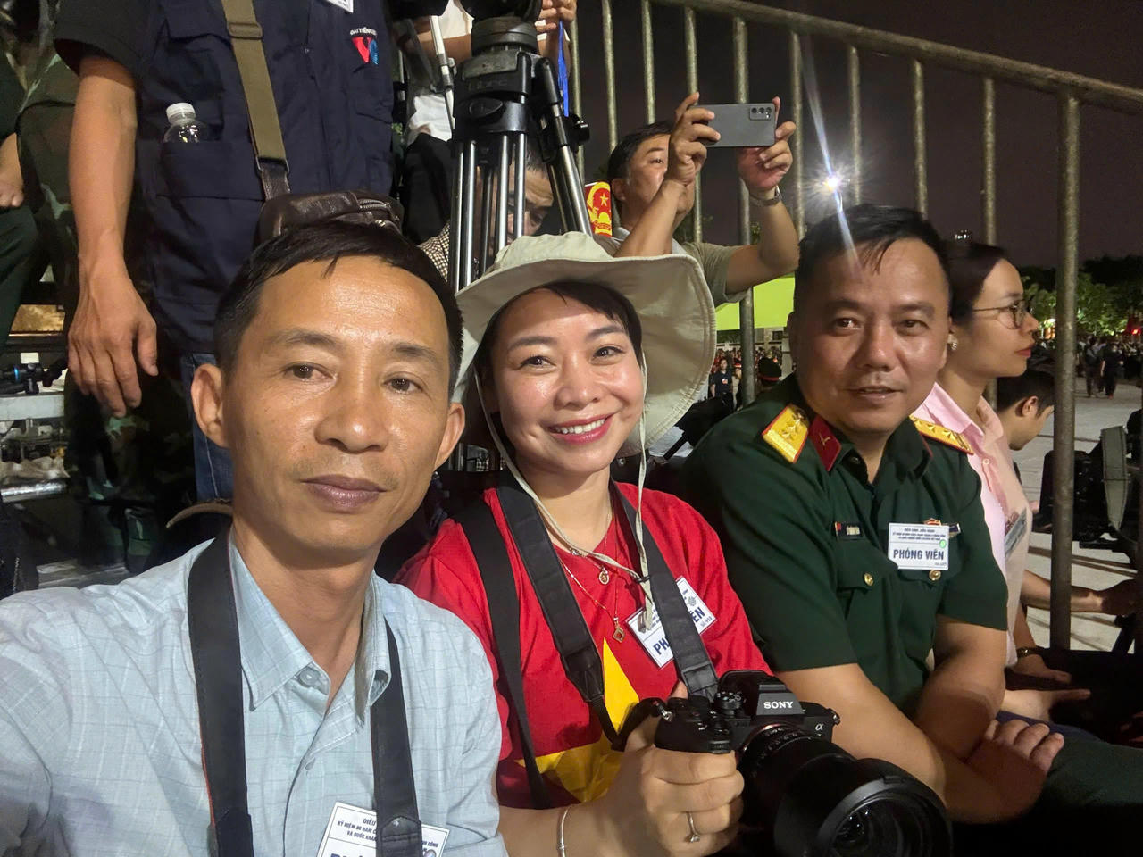 Nhà báo Văn Duẩn (ngồi đầu tiên) cùng nhà báo Mỵ Châu (ở giữa) chụp ảnh kỷ niệm trước giờ hợp luyện chính thức, tại Quảng trường Ba Đình, tối 21/8.