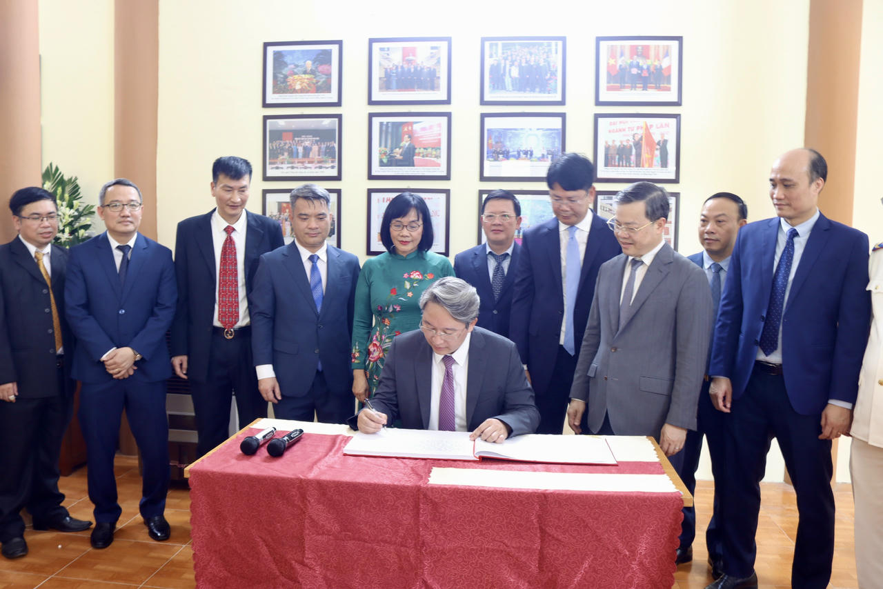 Bộ trưởng Nguyễn Hải Ninh viết sổ vàng lưu niệm. (Ảnh: H.G)