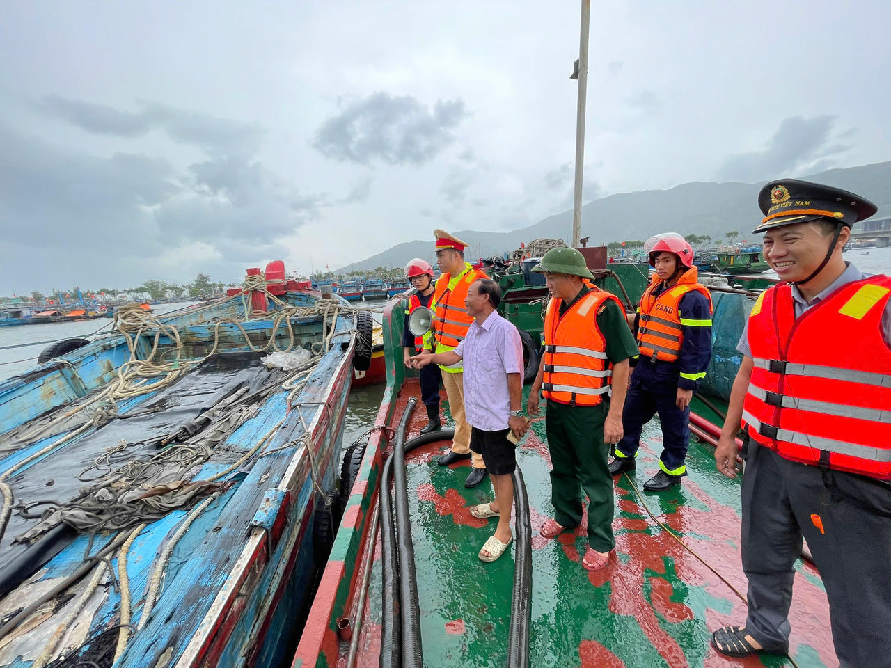 Lực lượng chức năng hướng dẫn ngư dân nêu đậu tàu thuyền an toàn.