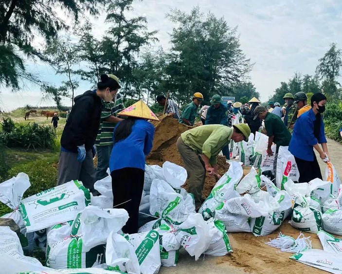 Hàng trăm người dân địa phương cùng lực lượng chức năng ở xã Đan Hải tiến hành gia cố đê có nguy cơ sạt lờ. Ảnh: PV