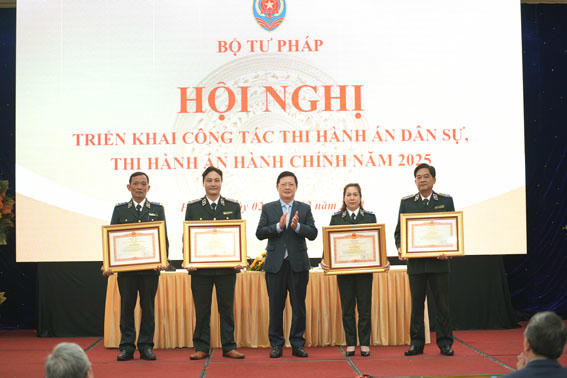 Thứ trưởng Bộ Tư pháp Mai Lương Khôi trao Bằng khen cho các tập thể, cá nhân có thành tích xuất sắc trong công tác THADS. (Ảnh: PV)