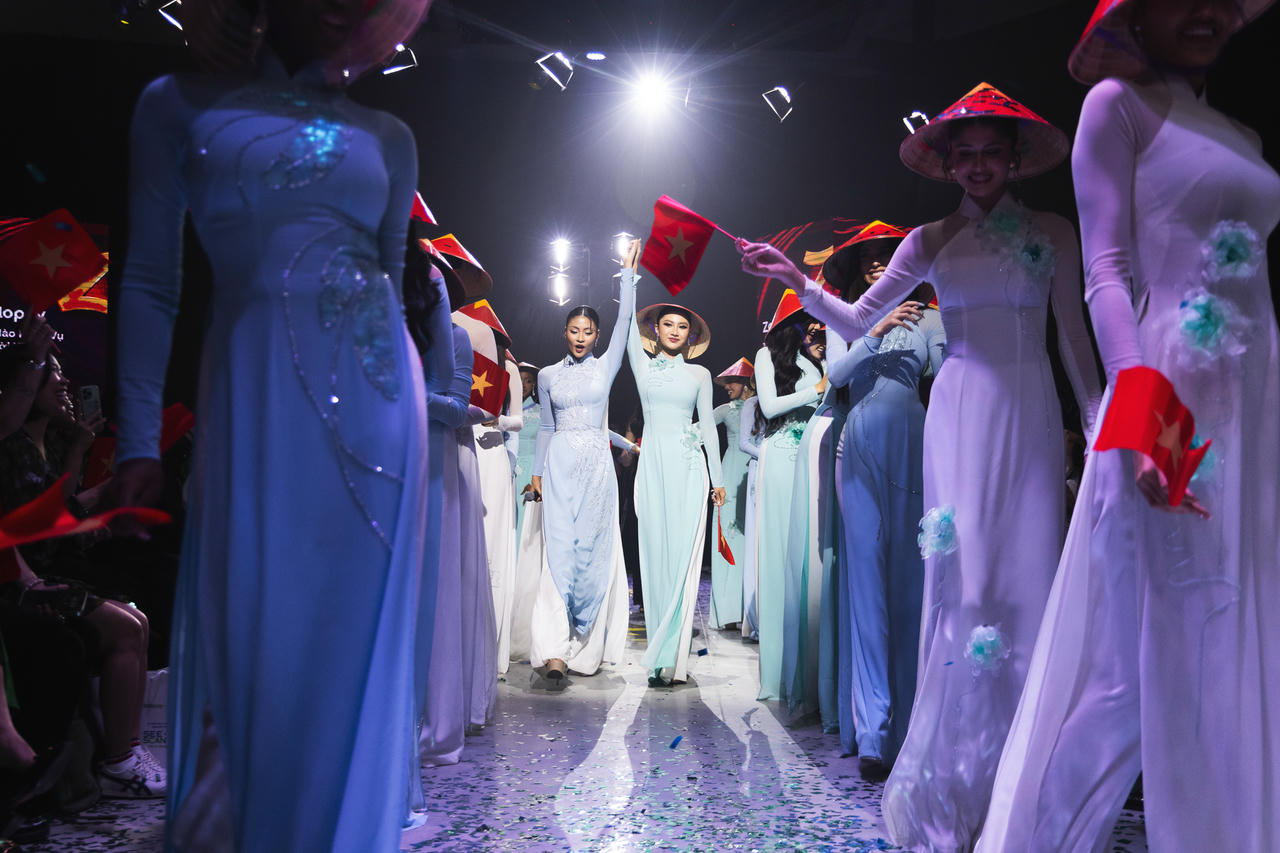 Các người đẹp rạng rỡ khi trình diễn áo dài, đội nón lá Việt. Ảnh: UNI