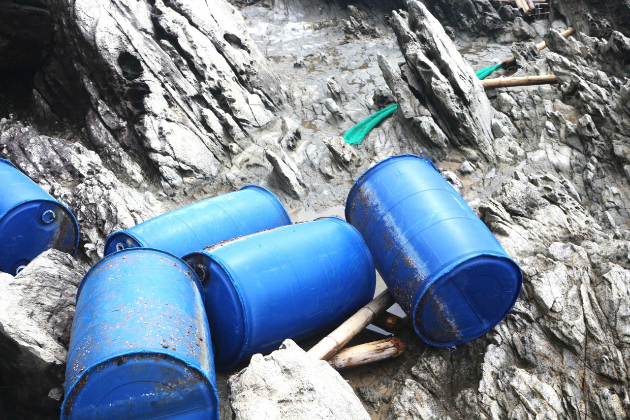 Từng chiếc phao của lồng bè nằm sâu trong ghềnh đá, gợi cảnh tan hoang.