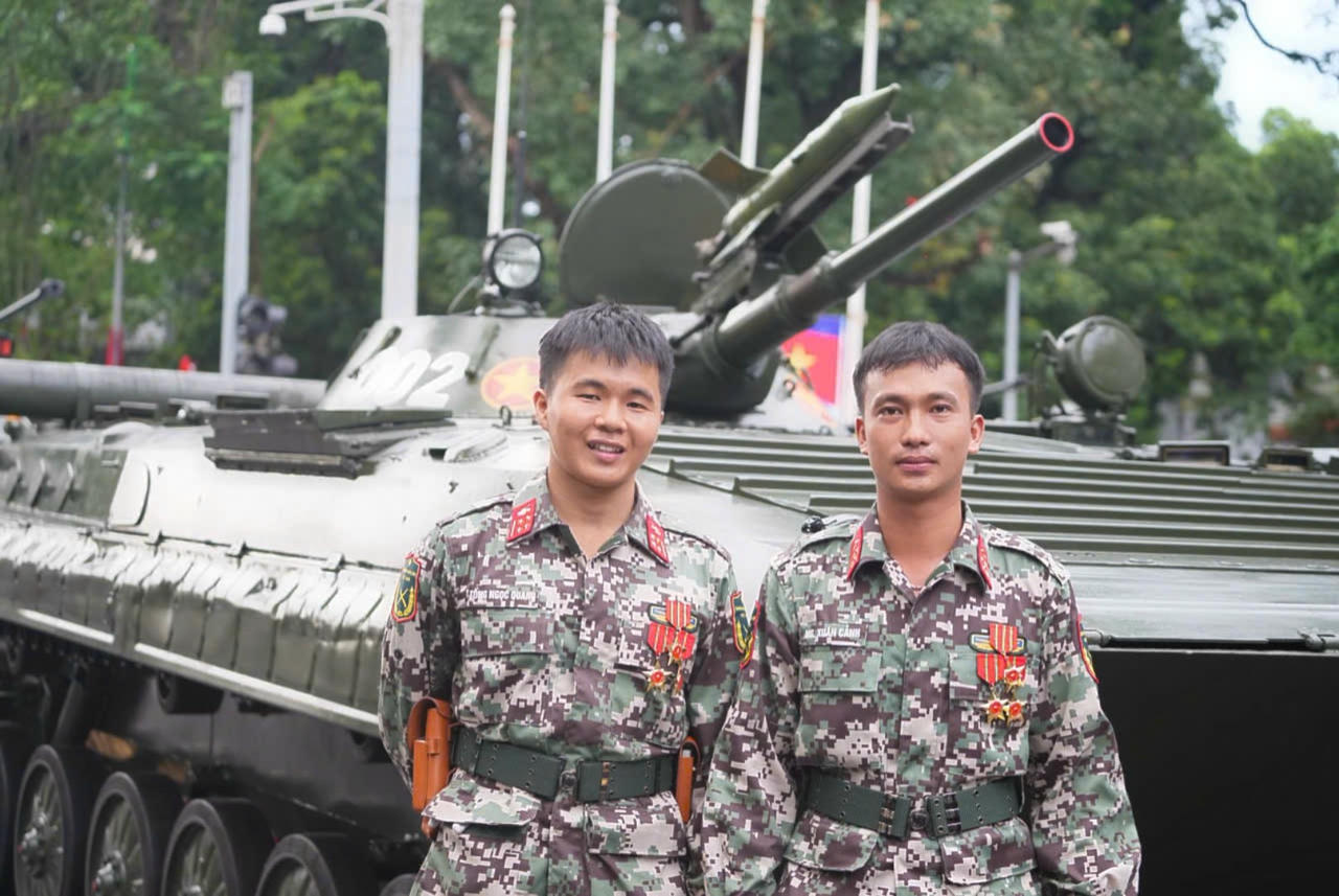 Thượng úy chuyên nghiệp Nguyễn Xuân Cảnh (đứng ngoài cùng bên phải) và Trung úy Tống Ngọc Quang (đứng bên trái) Nguồn ảnh Mỵ Châu