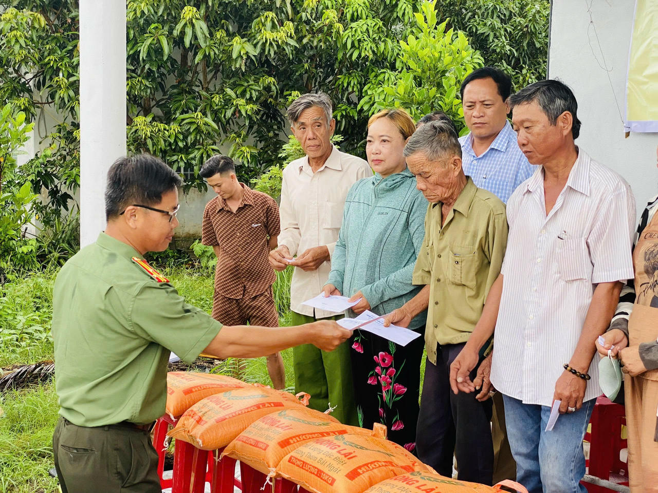 Thượng tá Hồ Việt Tiếng - Phó Trưởng Phòng An ninh chính trị nội bộ (Công an tỉnh Cà Mau) tặng quà cho các hộ dân.