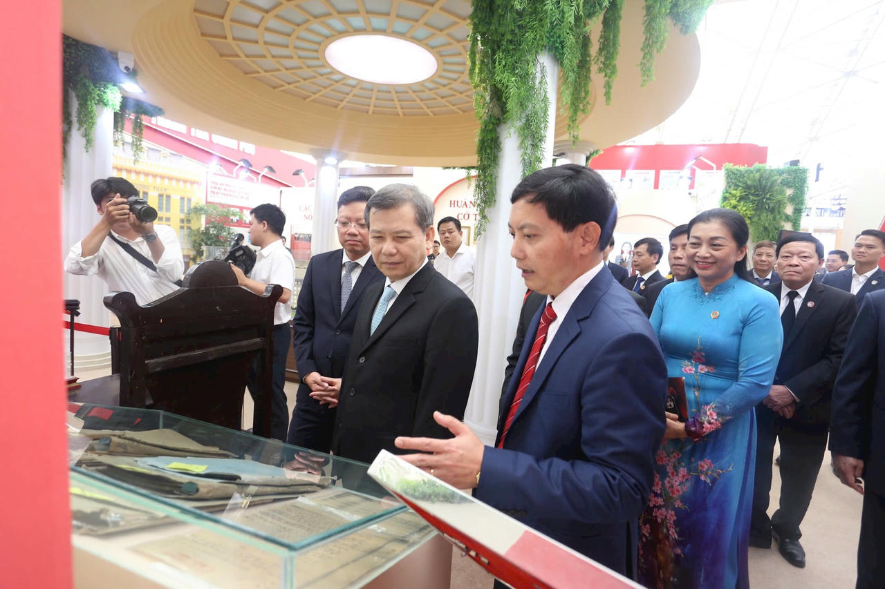 Tổng Biên tập Báo Công lý Trần Đức Vinh báo cáo Chánh án Tòa án nhân dân tối cao Lê Minh Trí về các nội dung tại không gian triển lãm của Ngành. (Ảnh: Công Lý)