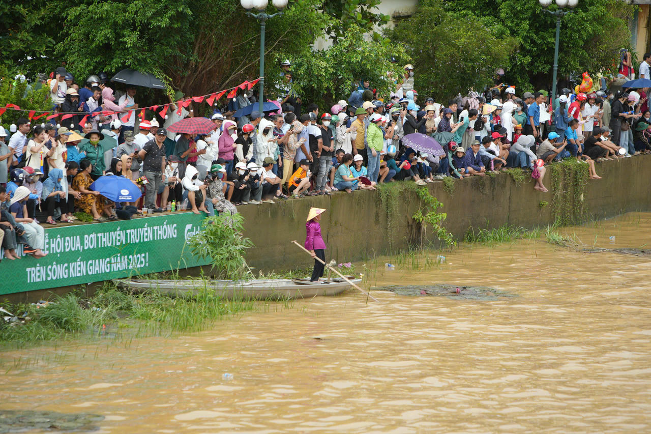 Hai bên bờ, hàng nghìn cổ động viên cổ vũ các thuyền bơi.