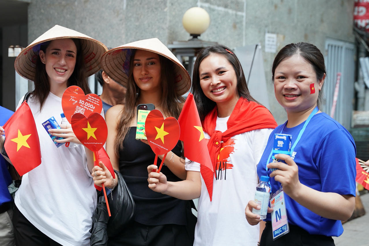 Không chỉ với người dân trong nước, không khí lễ hội đã lan tỏa đến với những người khách nước ngoài đang có mặt tại Hà Nội. Các cô gái nước ngoài hào hứng thưởng thức các sản phẩm sữa của Vinamilk tại 1 điểm tiếp sức dinh dưỡng. (Ảnh: Vi Nam)