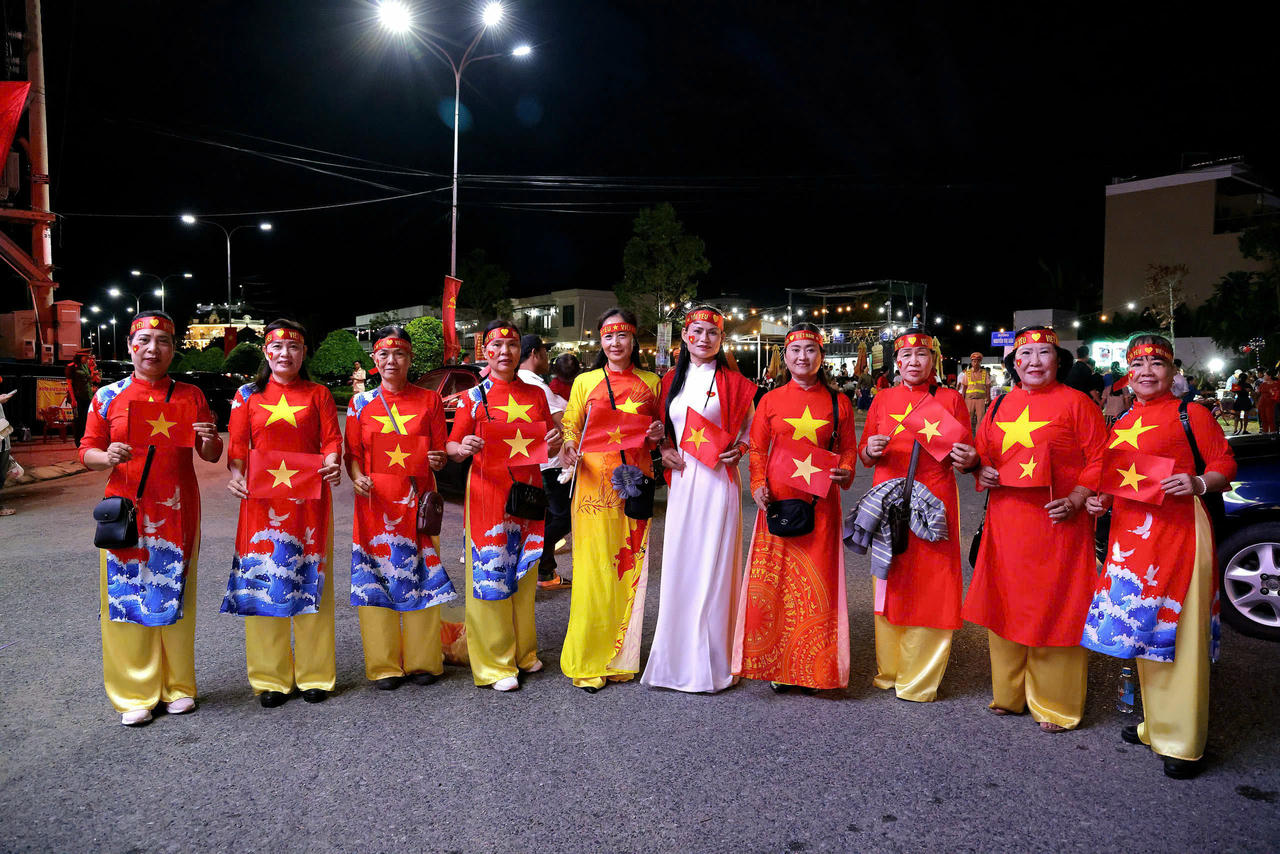 Nhiều người dân mặc trang phục cờ đỏ sao vàng để chào mừng.